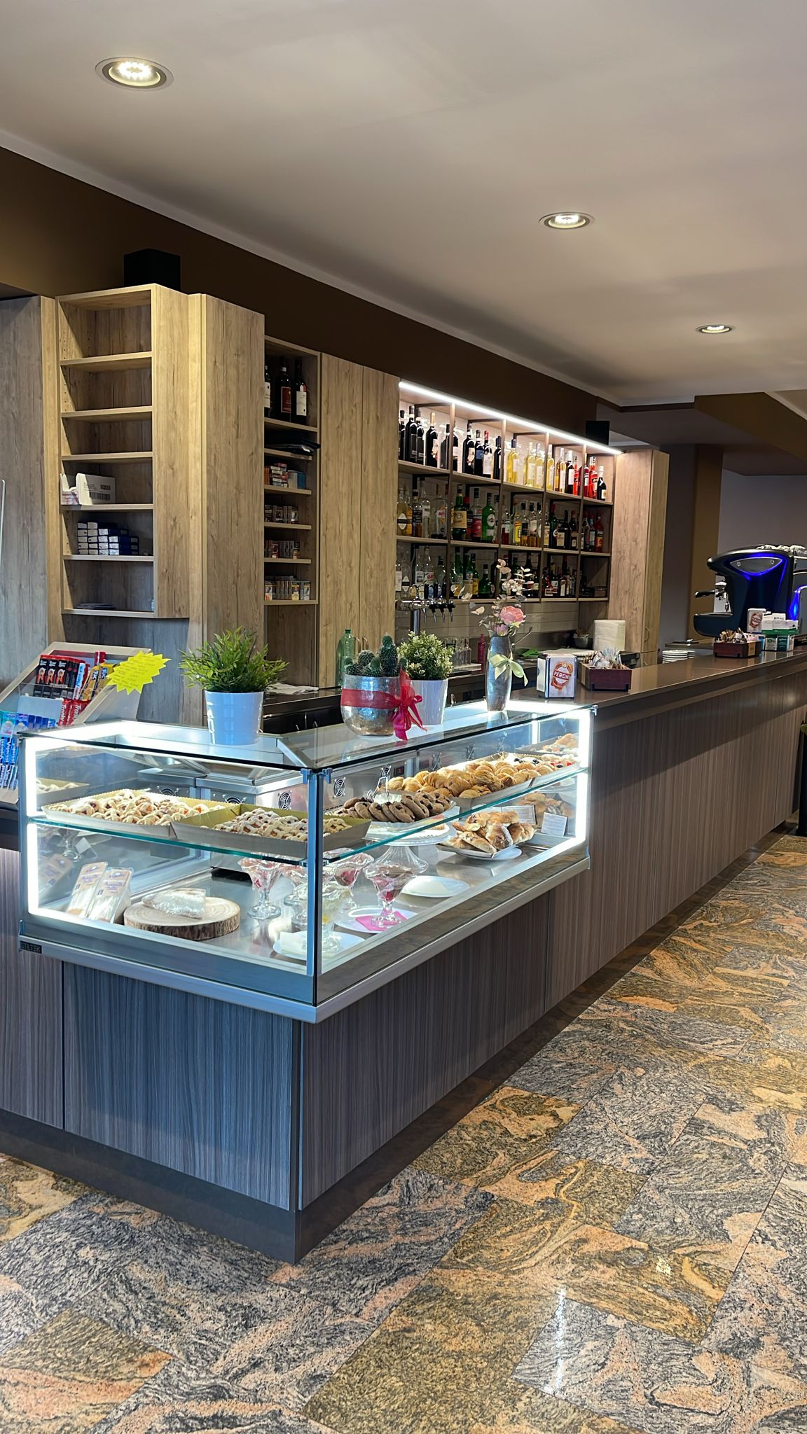 Bancone di un bar con vetrina di dolci.